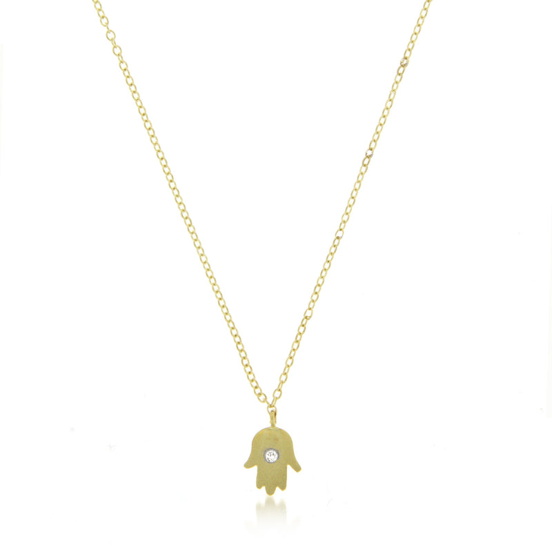 yellow gold hamsa hand necklace with centered diamond bezel